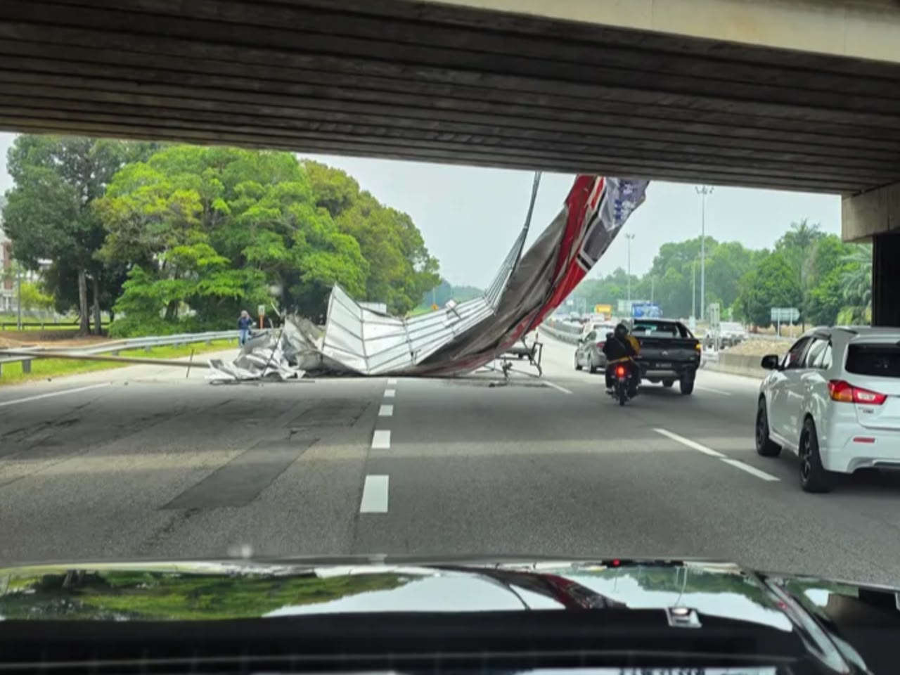 A collapsed billboard structure blocking lanes on the NKVE near Bukit Jelutong, Shah Alam.
